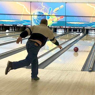 A man throwing a bowling ball