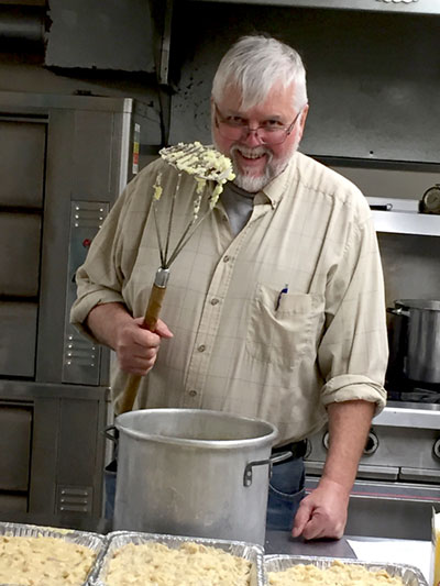 A guy making a big batch of mashed potatoes